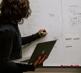 A woman draws on a whiteboard